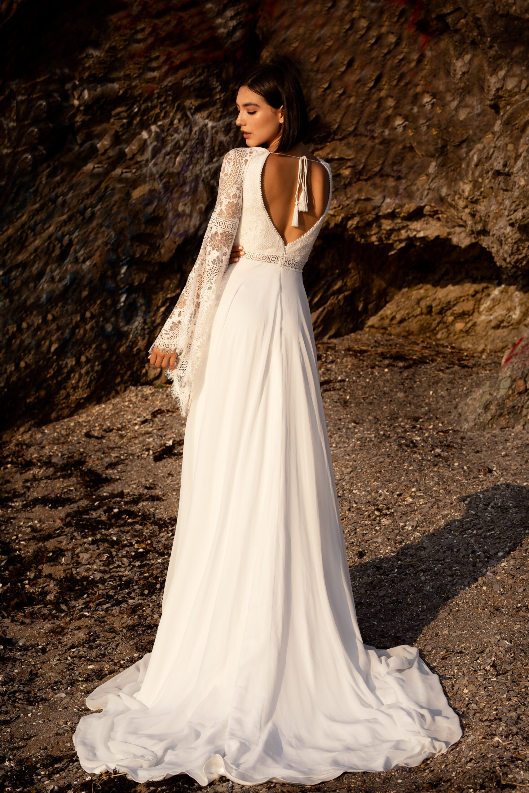 Rückenansicht des Boho Brautkleids Amelie mit tiefem V-Rücken, Spitzenärmeln und langer Schleppe
