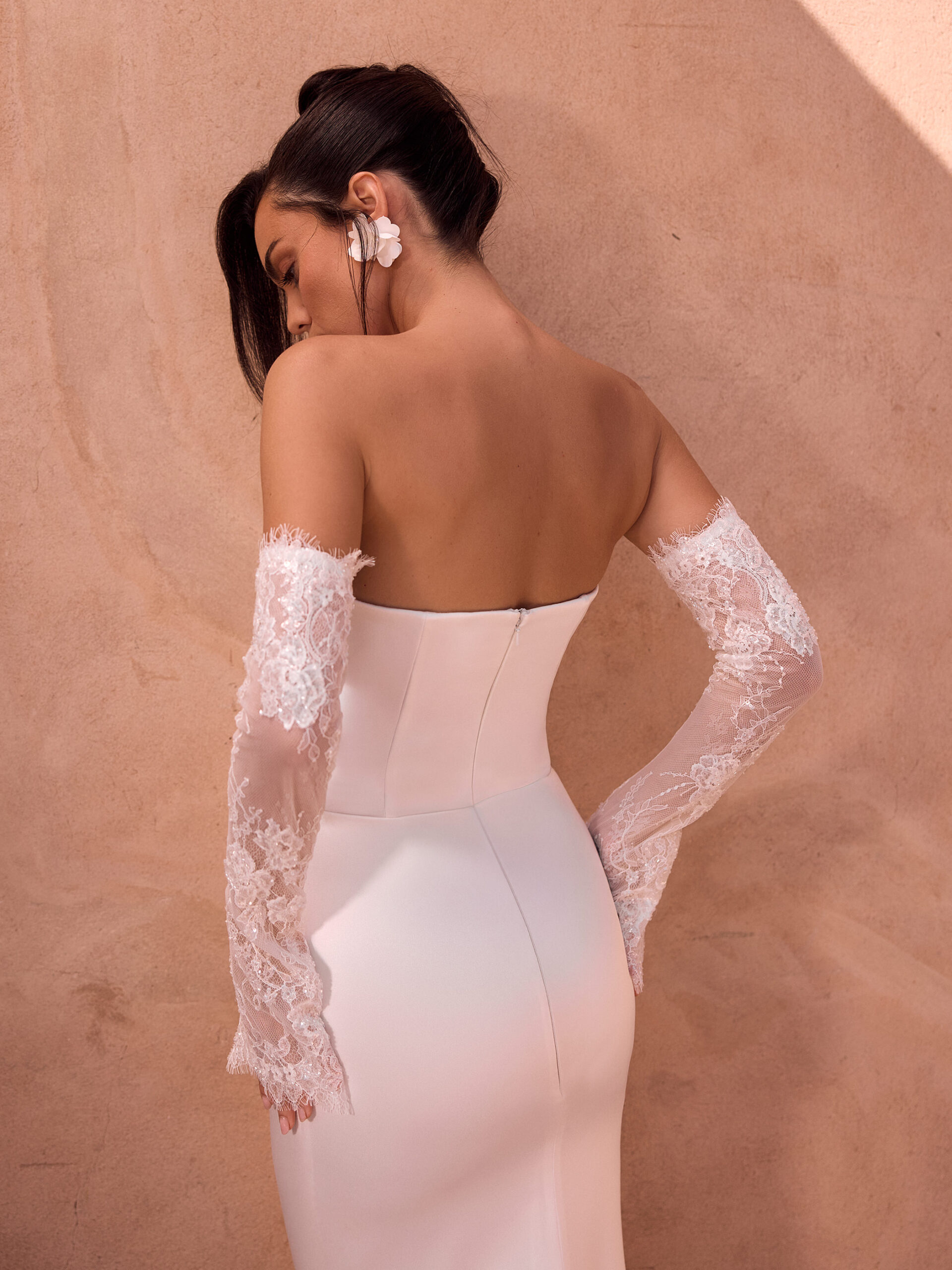Detailansicht des trägerlosen Brautkleids Malva mit offenem Rücken und floralen Spitzenstulpen